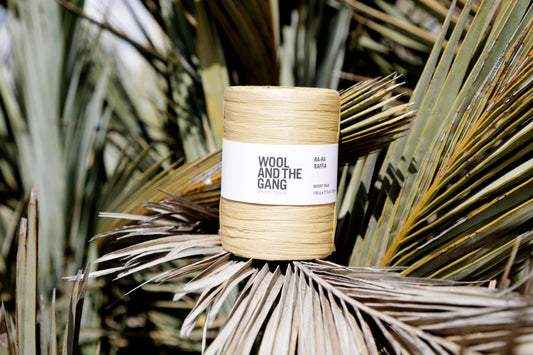 Wool and the Gang yarn roll on a palm leaf